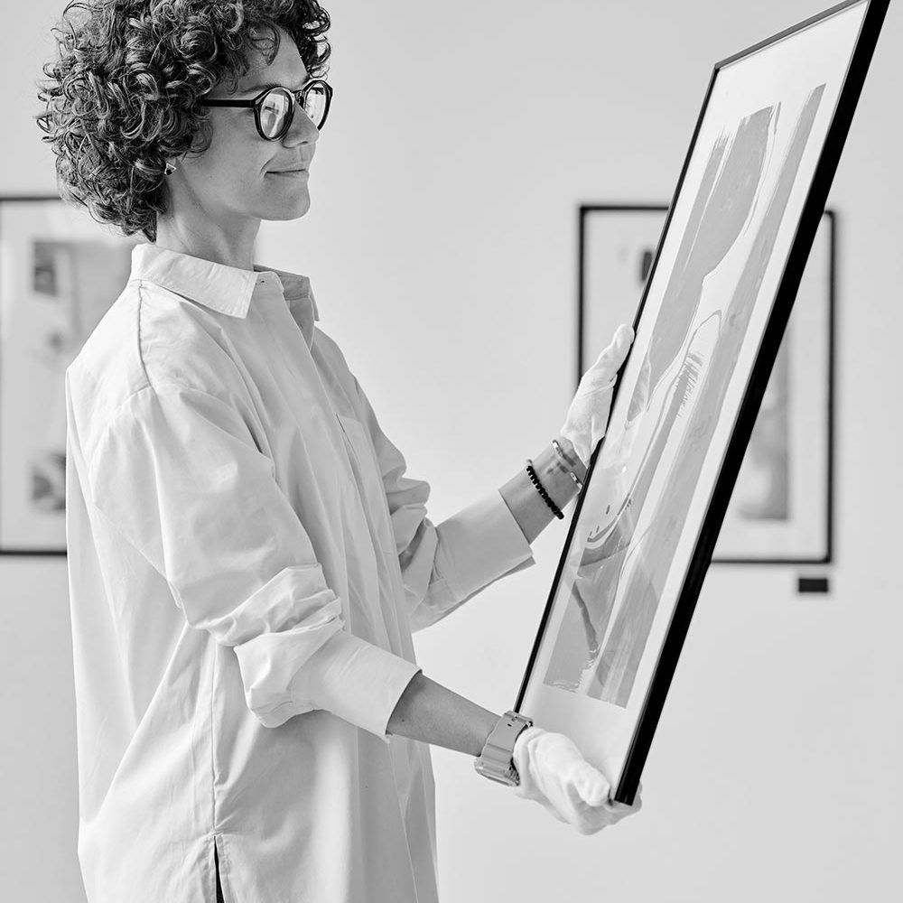 Gallery worker working with modern art Gallery worker working with modern art in art gallery preparing for exhibition