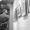Rear view of young man in formal wear walking along the corridor of art gallery and looking at paintings on the wall